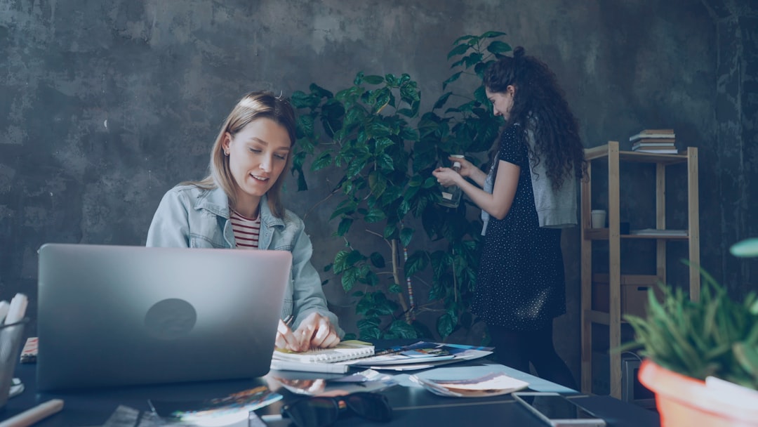 Two women work together in a creative office