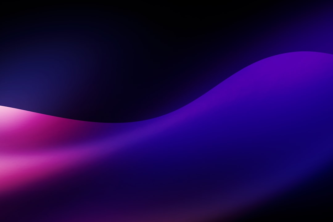 A smooth abstract wave of purple and pink light against a dark background